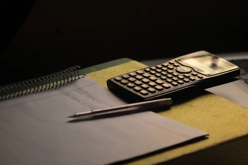 Calculadora y cuaderno sobre un escritorio